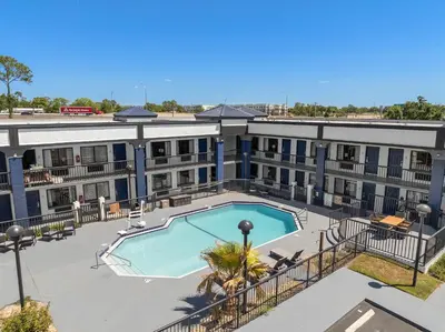 an aerial view of a building with a swimming pool at Baymont by Wyndham Orlando East in Orlando