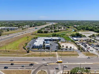 an aerial view of a parking lot next to a highway at Baymont by Wyndham Orlando East in Orlando