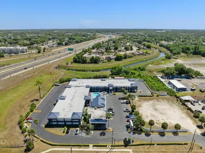 an aerial view of a parking lot next to a highway at Baymont by Wyndham Orlando East in Orlando