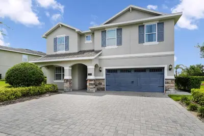 a large house with a driveway at Striking Home With Games, Outdoor Kitchen Near Disney With Waterpark & Resort Access At Encore Resort - 7742Ff in Kissimmee