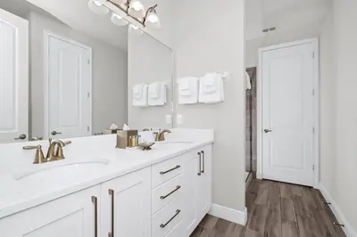 a white bathroom with two sinks and a mirror at Striking Home With Games, Outdoor Kitchen Near Disney With Waterpark & Resort Access At Encore Resort - 7742Ff in Kissimmee