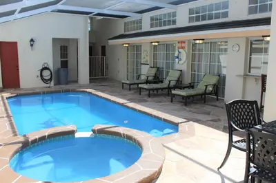 a large swimming pool with chairs and chairs around it at Crayson Villa LF811 in Kissimmee