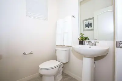 a white bathroom with a toilet and a sink at Four Bedroom Close to Disney 5149A in Kissimmee