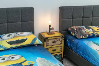 a bedroom with two beds and a night stand with a minion pillow at Sonoma Resort 7 Bedroom Home with Pool 1849 in Kissimmee