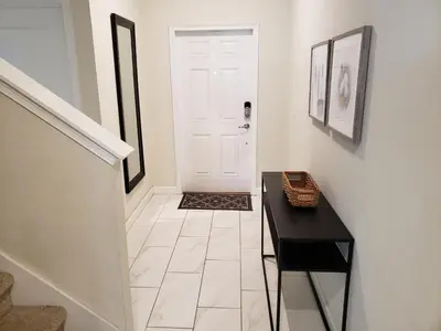 a hallway with a black table and a white door at 4 Bedroom Private Lakefront Town Home at Storey Lake near Disney World Parks in Kissimmee