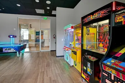 a room with two arcade games and a pool table at Regal Oaks Resort Vacation Townhomes by IDILIQ in Orlando