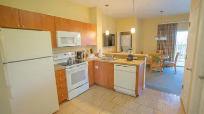 a kitchen with a white refrigerator and a table at Barefoot Suite in Orlando