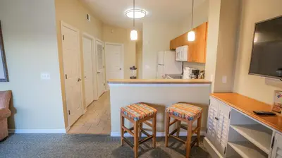a small kitchen with two stools at a counter at Barefoot Suite in Orlando