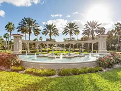a fountain in a park with palm trees in the background at Margaritavilla at Emerald Island in Kissimmee