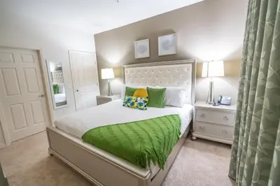a bedroom with a bed with a green blanket at Dream Vacation Home! in Kissimmee