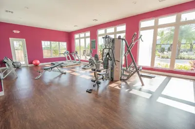 a gym with exercise equipment in a room with red walls at Dream Vacation Home! in Kissimmee