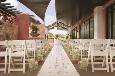 a corridor with white chairs and a aisle with flowers at Embassy Suites by Hilton Orlando Lake Buena Vista South in Kissimmee