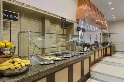 a buffet line in a restaurant with bananas and other food at Embassy Suites by Hilton Orlando Lake Buena Vista South in Kissimmee