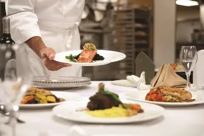 a chef holding a plate of food on a table at Embassy Suites by Hilton Orlando Lake Buena Vista South in Kissimmee