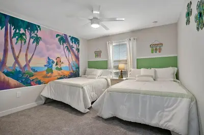 two beds in a room with a painting on the wall at 3083 TS-SVH Storey Lake in Kissimmee
