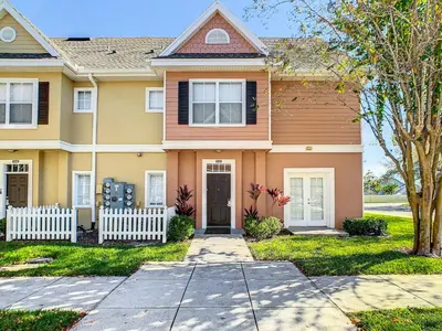 a house with a fence in front of it at 4 Bedroom Townhouse in a Gated Resort! in Kissimmee