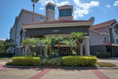 a hotel building with a clock tower and palm trees at La Quinta by Wyndham Orlando I Drive/Conv Center in Orlando