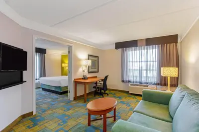 a hotel room with a couch and a bed at La Quinta by Wyndham Orlando I Drive/Conv Center in Orlando