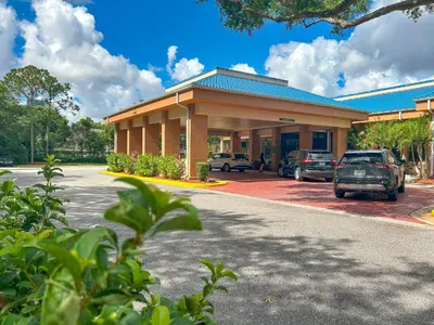 a building with cars parked in front of it at Hotel Monreale Express & Studios IDrive District in Orlando