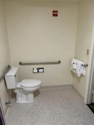 a bathroom with a toilet and a tiled floor at Baymont by Wyndham Orlando South in Orlando