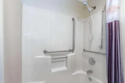 a bathroom with a shower with a shower curtain at Baymont by Wyndham Orlando South in Orlando