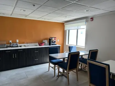 a room with a table and chairs and a kitchen at Baymont by Wyndham Orlando South in Orlando