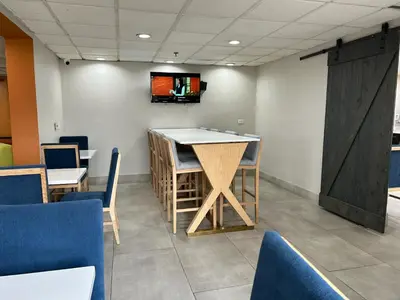 a bar in a room with chairs and a tv at Baymont by Wyndham Orlando South in Orlando