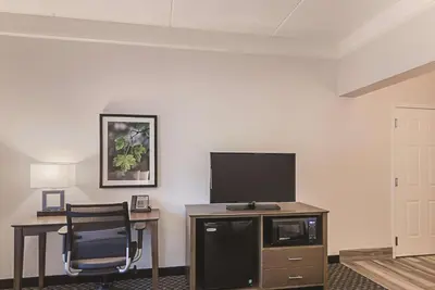 a room with a television and a desk with a chair at La Quinta by Wyndham Orlando UCF in Orlando