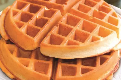 a stack of waffles on a white plate at La Quinta by Wyndham Orlando UCF in Orlando