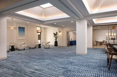 a lobby with a waiting room with chairs and tables at DoubleTree Suites by Hilton Orlando at Disney Springs in Orlando