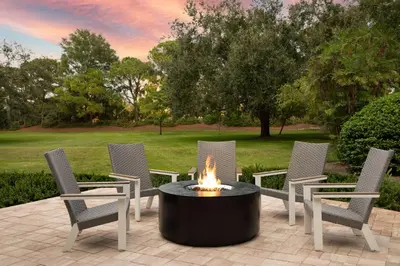 a fire pit in a patio with chairs and a table at DoubleTree Suites by Hilton Orlando at Disney Springs in Orlando