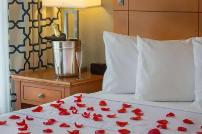 a bed with red rose petals laying on it at Homewood Suites by Hilton Orlando-International Drive Convention Center in Orlando