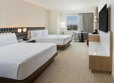 a hotel room with two beds and a table at Hilton Orlando in Orlando
