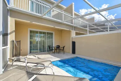 a swimming pool on a patio with chairs and a table at Silver Creek - 3 Bed Townhouse Wsplashpool-5003Sc in Orlando