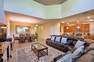 a living room with a couch and a dining room at Very Private Pool & Spa, Spacious, Wifi - 3507Pp in Kissimmee