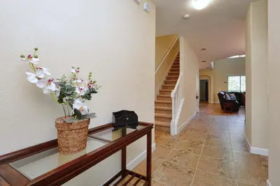 a hallway with a table with a vase of flowers on it at Very Private Pool & Spa, Spacious, Wifi - 3507Pp in Kissimmee