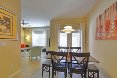 a dining room and living room with a table and chairs at Paradise Palms-4 Bed Townhome W-Splashpool-3035Pp in Kissimmee