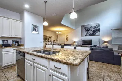 a kitchen with a sink and a living room with a couch at Conservation View, Resort, Pool Home-3116Pp in Kissimmee