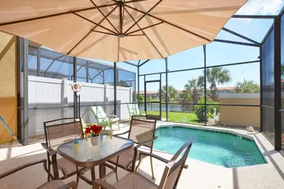 a patio with a table and chairs and a pool at Encantada -4 Bedroom Townhome W- Splashpool-2651En in Kissimmee