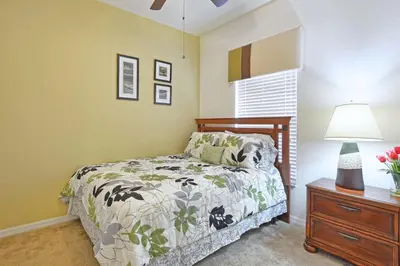 a bedroom with a bed and a table with a lamp at Encantada -4 Bedroom Townhome W- Splashpool-2651En in Kissimmee
