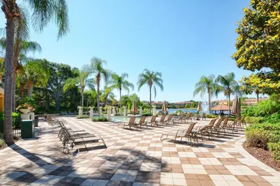 a row of chairs on a patio with palm trees at Encantada -4 Bedroom Townhome W- Splashpool-2651En in Kissimmee