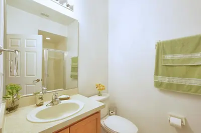 a bathroom with a sink and a toilet and a mirror at Encantada -4 Bedroom Townhome W- Splashpool-2651En in Kissimmee