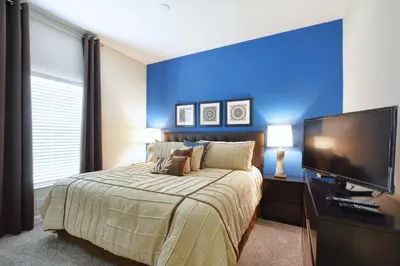 a bedroom with a large bed and a flat screen tv at Lakefront Retreat Wpvt Splashpool-1617St in Kissimmee