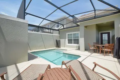 a patio with a swimming pool and chairs and a table at Lakefront Retreat Wpvt Splashpool-1617St in Kissimmee