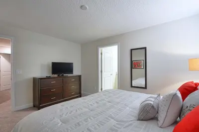 a bedroom with a bed and a dresser with a television at Lakefront Retreat Wpvt Splashpool-1617St in Kissimmee