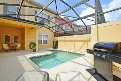 a swimming pool with a grill and a house at Bright & Cheery Decor, Townhome Wspashpool-3015Pp in Kissimmee