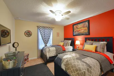 a bedroom with two beds and an orange wall at Paradise Palms-4 Bed Townhouse Wsplashpool3622Ppr in Kissimmee
