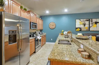 a kitchen with a stainless steel refrigerator and cabinets at Paradise Palms-4 Bed Townhouse Wsplashpool3622Ppr in Kissimmee