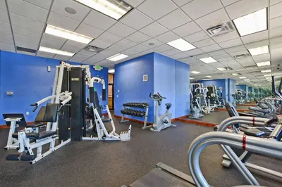 a gym with blue walls and tread machines at Paradise Palms-4 Bed Townhouse Wsplashpool3622Ppr in Kissimmee