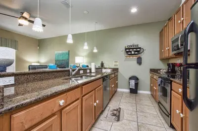 a large kitchen with wooden cabinets and a sink at Pvt Splashpool, Bbq Grill, Close To Parks-3057Pp in Kissimmee